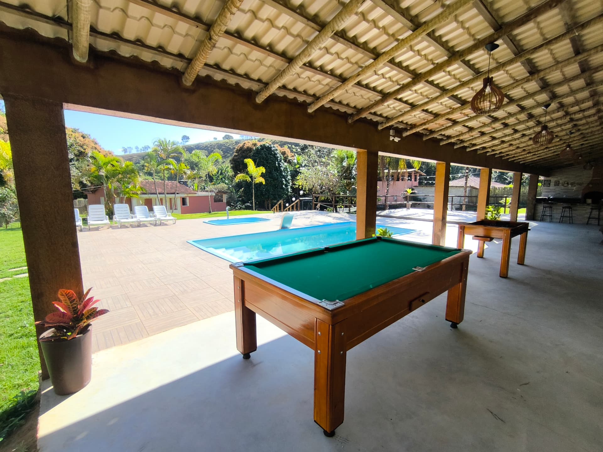 Mesa de sinuca na varanda com vista para a piscina