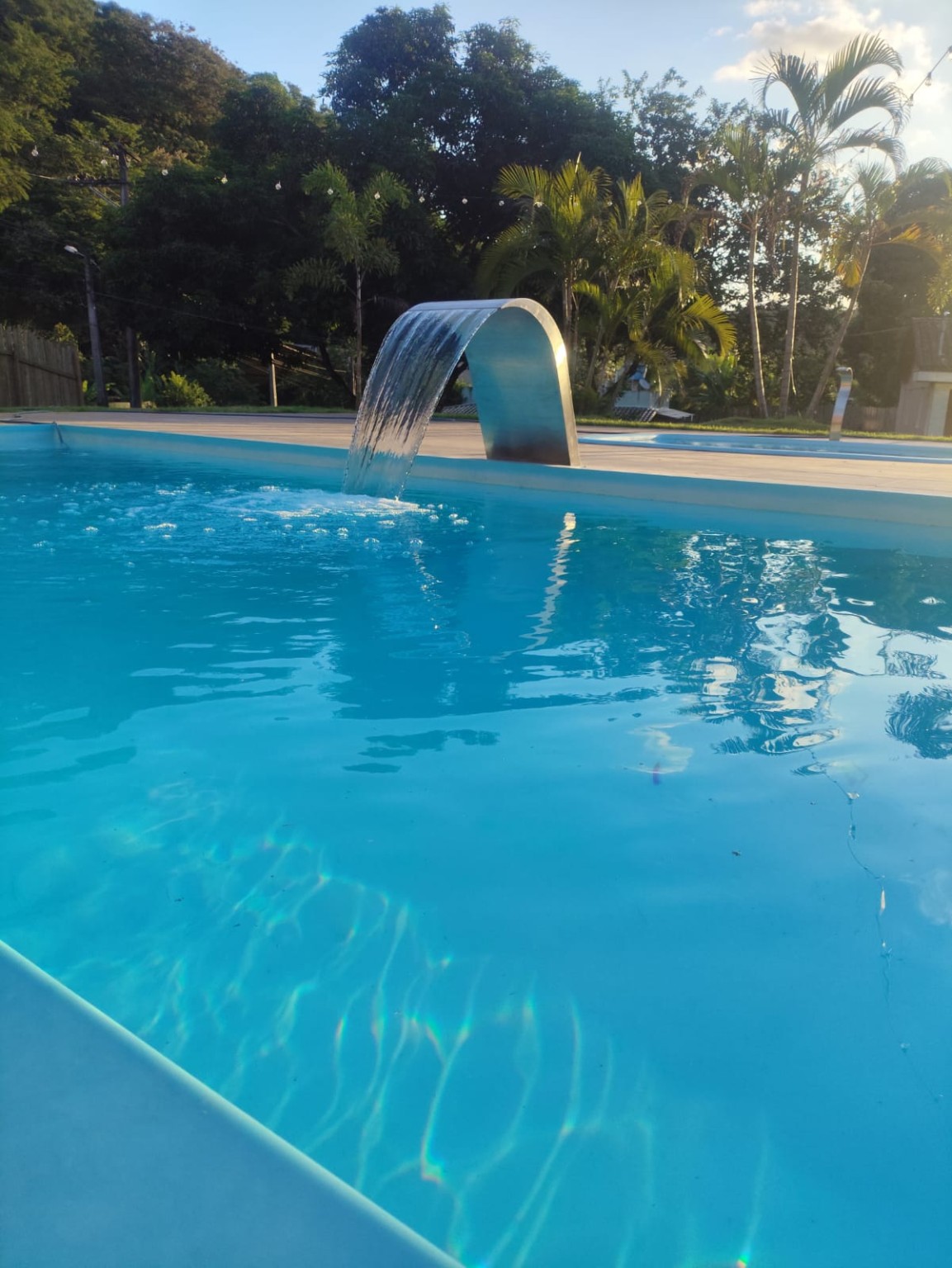 Cascata da piscina ao pôr do sol